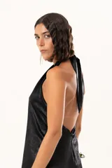 Vestido midi de satén color negro, con escote halter cruzado y ruedo terminado en flecos largos.