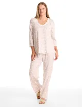 Conjunto de pijama compuesto por una remera de mangas largas con escote redondo y bolsillo frontal, y un pantalón largo con cintura elástica. Ambas piezas presentan un estampado floral y detalles de apliques de crochet en el cuello y el bolsillo.