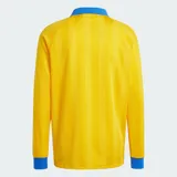 Camiseta de manga larga Adidas Originals, de corte holgado y color amarillo con rayas verticales sutiles en tono más oscuro y detalles en azul en cuello polo, puños y las clásicas franjas en las mangas. Cuenta con el logo bordado en el pecho.
