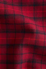 Pantalón de franela de algodón suave con estampado a cuadros en tonos rojos y negros. Presenta cintura elástica con cordón ajustable, cierre decorativo y bolsillos laterales al bies.