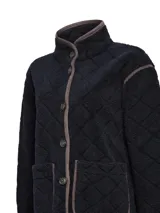 Chaqueta polar acolchada color azul marino, con diseño de rombos y ribetes en contraste color marrón. Presenta cuello alto, cierre frontal con botones y bolsillos frontales estructurados.