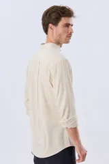 Camisa de lino y algodón color blanco, con cuello mao, manga larga y medio cierre frontal con botones.