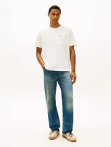Remera Tommy Hilfiger de corte amplio y estilo urbano, confeccionada en punto de malla de mezcla de algodón en color blanco. Presenta cuello redondo, hombros ligeramente caídos y un bolsillo de parche en el pecho con el logo bordado.