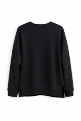 Buzo de cuello redondo y manga larga, confeccionado en tejido liso de color negro, con diseño de corte holgado y aberturas laterales en el ruedo.