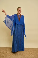 Capa de gasa azul con diseño versátil que permite múltiples formas de uso, aportando transparencia y elegancia al vestuario.