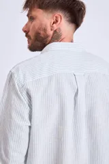 Camisa de corte regular con diseño de rayas verticales finas en tonos claros, cuello clásico y mangas largas con puños abotonados.