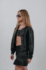 Campera bomber de cuero color marrón, con mangas abullonadas, puños elásticos y cierre frontal con botones a presión.