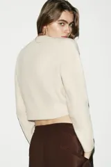 Jersey de punto suave con cuello redondo y manga larga, con terminaciones en rib en puños, cuello y ruedo.