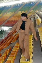 Pantalón camel de gabardina elastizada, corte sastrero, tiro bajo, con bolsillos delanteros, botón metálico y tajo en el lateral interno.