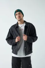 Campera negra de canvas de algodón grueso con bolsillos con cierre y botones a presión.