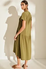Vestido midi color crudo de manga corta, con corte en la cintura y falda holgada con volados y detalle de pequeño bordado de hongo en el pecho.
