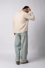 Camisa de lino blanca de manga larga, con cuello clásico y cierre frontal con botones. Corte recto y holgado.