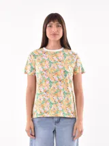 Remera de mangas cortas con cuello redondo y estampado floral en tonos amarillo, naranja, rosa y verde.
