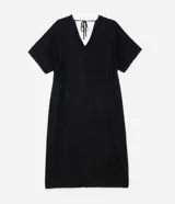 Vestido midi de jacquard color negro, con escote en V y cordón ajustable en la cintura. Presenta mangas cortas de estilo holgado y una textura sutil en el tejido de viscosa.