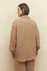 Camisa beige de manga larga con botones a tono.