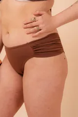 Bombacha de bikini tiro alto color azul marino, con frunce en los costados. Confeccionada con tela que contiene fibra LYCRA® XTRA LIFE™.