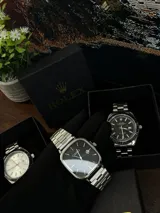 Reloj Casio Quartz con caja cuadrada plateada, esfera negra y correa de acero inoxidable plateada. Incluye fechador.