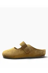 Zueco tipo bailarina de gamuza color camel, con diseño cerrado en la parte delantera, talón descubierto y una tira con hebilla metálica ajustable en el empeine.