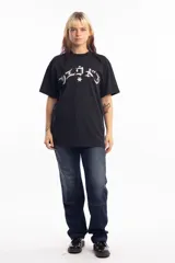 Remera negra de corte holgado con estampa frontal en color blanco con tipografía estilo gótico y una estrella central.