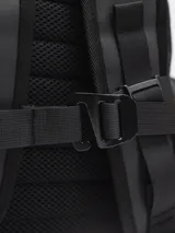 Mochila negra impermeable de estilo moderno y estético, con diseño opaco. Cuenta con compartimento principal con funda acolchada para computadora, varios bolsillos organizadores internos y bolsillos externos con cierre a los lados. Incluye correas ajustables con broche frontal para mayor estabilidad.