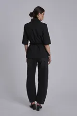 Blazer negro con mangas 3/4, solapas de muesca y corte entallado.