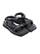 Sandalia plana color crema con plataforma baja y tiras acolchadas. Se ajusta con velcro en el tobillo.