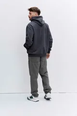 Buzo con capucha tipo canguro confeccionado en tela de corduroy color marrón. Presenta cordones blancos en contraste, bolsillo frontal tipo canguro y logo bordado sutil en el pecho.