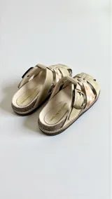 Sandalias de cuero color beige con arte pintado a mano en tonos marrones y blancos, hebilla lateral y suela de corcho y goma.