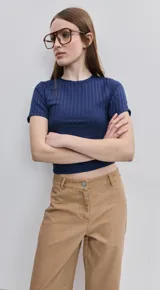 Pantalón verde militar de tiro medio y calce wide leg, con bolsillos laterales y cierre frontal con botón.