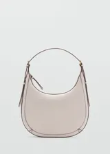Bolso de hombro tipo hobo en color beige, con diseño de media luna, cierre de cremallera y asa ajustable con hebillas laterales.