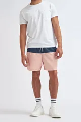 Short de baño con diseño de bloques de color, presentando una franja superior en azul marino y el resto de la prenda en color rosa. Cuenta con cintura elástica con cordón ajustable.