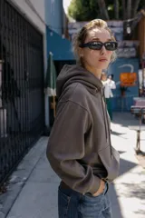 Sudadera de manga larga con capucha ajustable mediante cordones, bolsillo frontal tipo canguro y puños y ruedo en tejido rib.