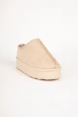 Zueco de gamuza color beige con interior forrado en piel sintética y plataforma de 5 cm de altura.