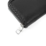 Billetera negra de símil cuero con cierre, logo metálico XL y detalle de trenzado en los bordes. Cuenta con 13 compartimentos y un bolsillo interno con cierre. Herrajes plateados.