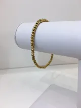 Pulsera elástica de acero quirúrgico con diseño de cuentas esféricas doradas de 4 mm de diámetro.