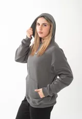 Canguro unisex de corte oversize confeccionado en felpa premium de alto gramaje. Presenta capucha, mangas largas con puños acanalados y diseño con bordado en la espalda que incluye la frase 'RESILIENCE BUILT IN SILENCE'.