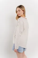 Remera manga larga color rosa con bolsillo en el pecho y corte irregular en el ruedo.