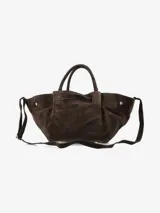 Cartera de mano estructurada en cuero negro con acabado mate. Presenta un diseño amplio con laterales voluminosos, asas cortas y un cierre frontal metálico tipo broche.