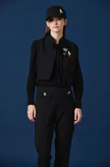 Chaleco negro de corte corto y estructurado, con cierre frontal y diseño minimalista.