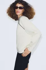 Jersey de punto de manga larga con cuello redondo, diseño en color azul marino con detalles de vivo en color blanco en el cuello y las costuras de las mangas.