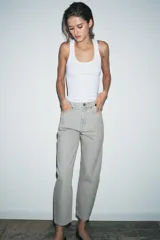 Jeans de tiro medio con corte tapered, confeccionados en denim de color negro con costuras en contraste. Presentan diseño de cinco bolsillos, trabillas en la cintura y cierre frontal con cremallera y botón.