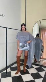 Vestido corto de dos piezas compuesto por una base strapless con frunces y acabado satinado, acompañada de una capa transparente desmontable de corte asimétrico.