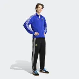 Pantalón deportivo Adidas Originals de la selección argentina, color negro con las icónicas tres tiras blancas laterales. Presenta el escudo de la AFA bordado en el muslo y corte clásico con cintura elástica y cordón de ajuste.