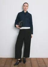 Pantalón de vestir negro de tiro medio y corte recto, con detalle de pinzas y bolsillos laterales.