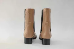 Botas de cuero color beige con elásticos laterales negros, taco cuadrado y punta cuadrada.