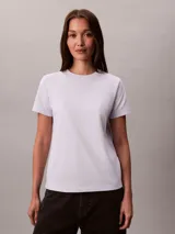 Remera Calvin Klein de manga corta y cuello redondo, confeccionada en tejido de punto de algodón. Presenta un diseño clásico de corte regular con el logo de la marca bordado discretamente en el pecho.
