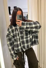 Chaqueta de denim en color gris oscuro, con corte oversize, mangas amplias, cuello camisero y bolsillos frontales con solapa.