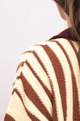 Vestido camisola de tejido de punto fresco, con rayas verticales en tonos marrones y beige, cuello polo marrón, mangas cortas y cierre frontal con botones de madera.