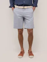 Bermuda clásica de hombre, corte regular fit, color celeste, con cierre de cremallera y botón, bolsillos laterales y traseros.