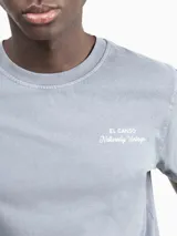 Camiseta celeste de manga corta con cuello redondo y estampado en la espalda con el logo de la marca y la frase "Naturally Vintage".